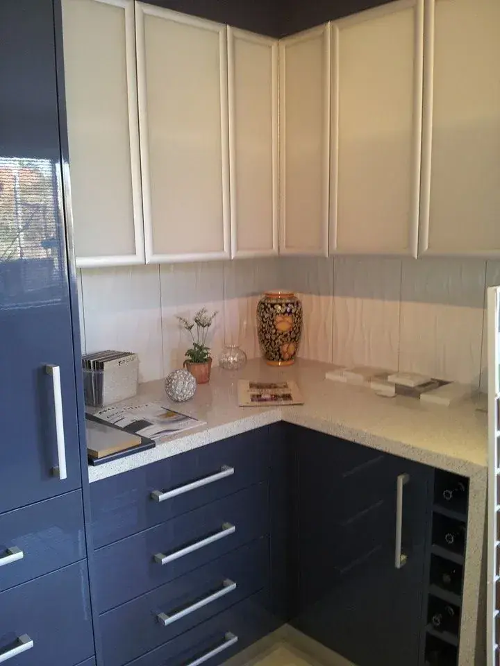 Two-tone corner cabinetry with dark lower drawers and cream upper cupboards
