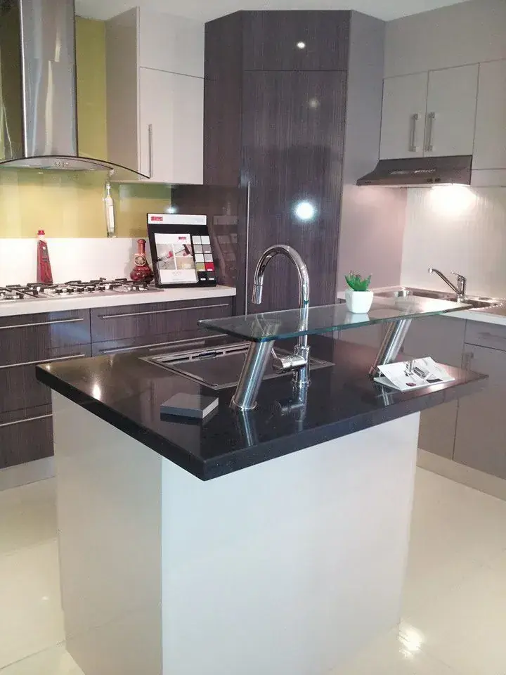 Dark kitchen island with glossy cabinetry and pendant lighting