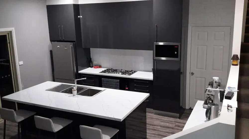 Black and white fitted kitchen cabinetry around a central island
