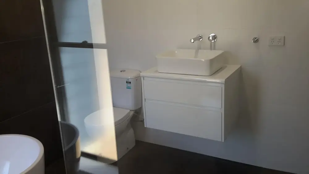 Compact bathroom with white wall-hung vanity and square vessel basin